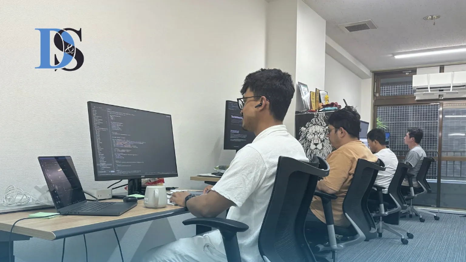 Engineers at a row of desks in the D&S, Inc. office