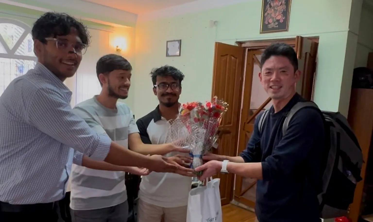 Engineers at the N.D.S. Venture office in Kathmandu presenting a bouquet of flowers to a visitor