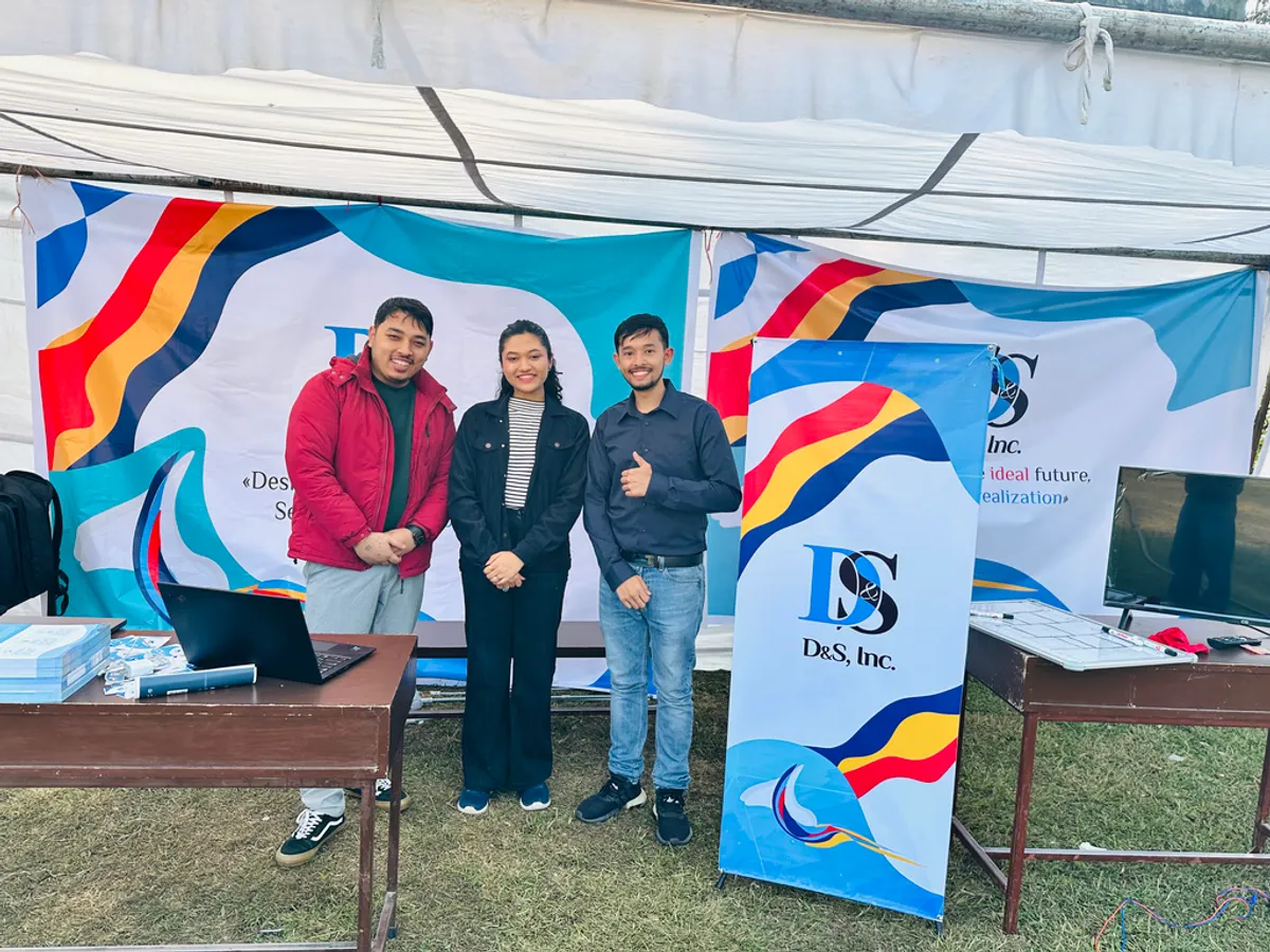Three D&S staff standing in the company's outdoor exhibition booth at KU IT Meet, surrounded by D&S banners